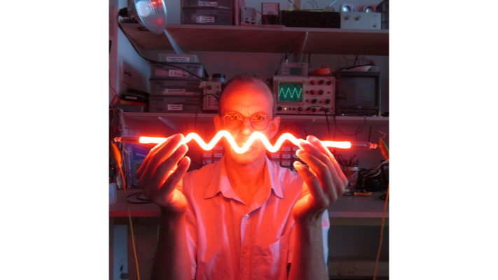 Self-portrait of James Schidlowsky with neon resistance symbol